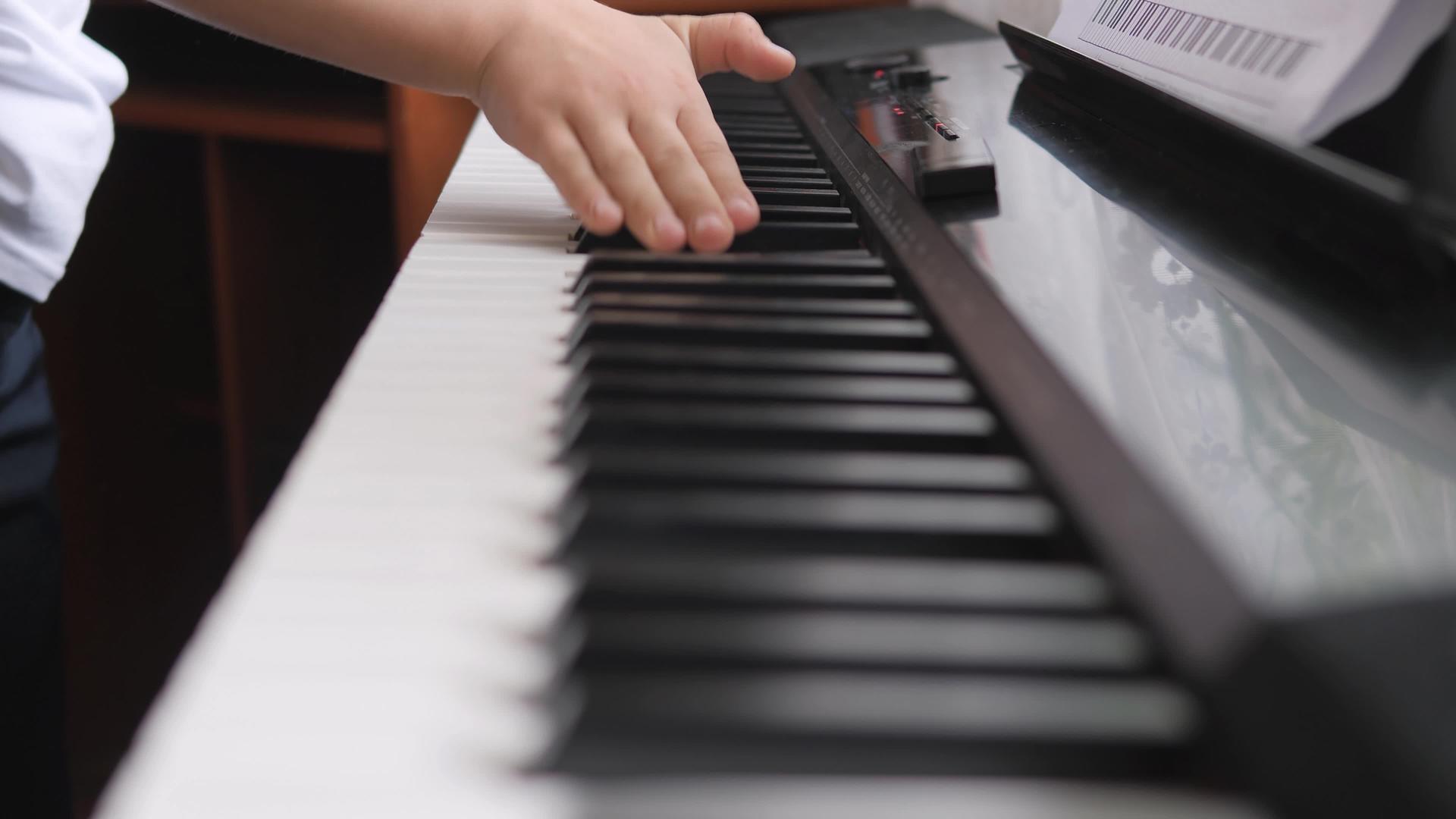 电子钢琴手指按下钢琴键在音乐课上孩子们的手放在钢琴键盘上视频的预览图