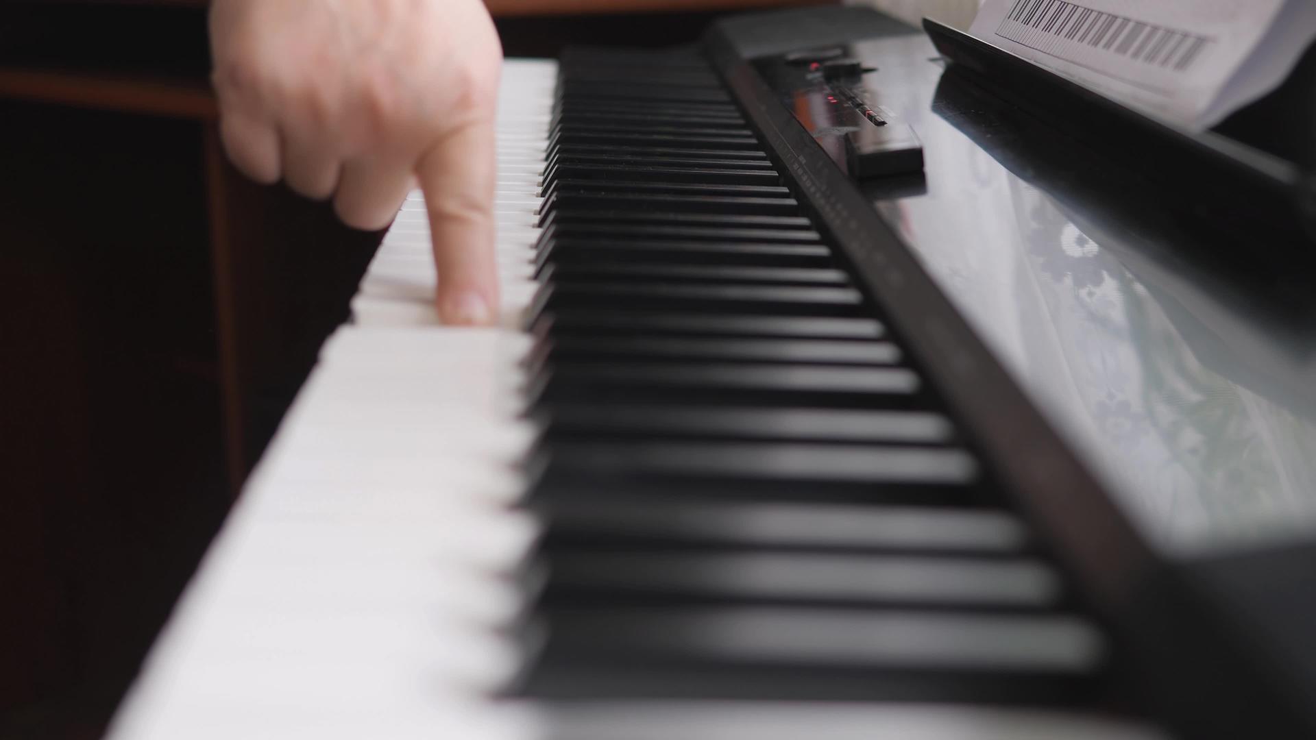 电子钢琴手指按下钢琴键孩子的手放在钢琴键盘上视频的预览图