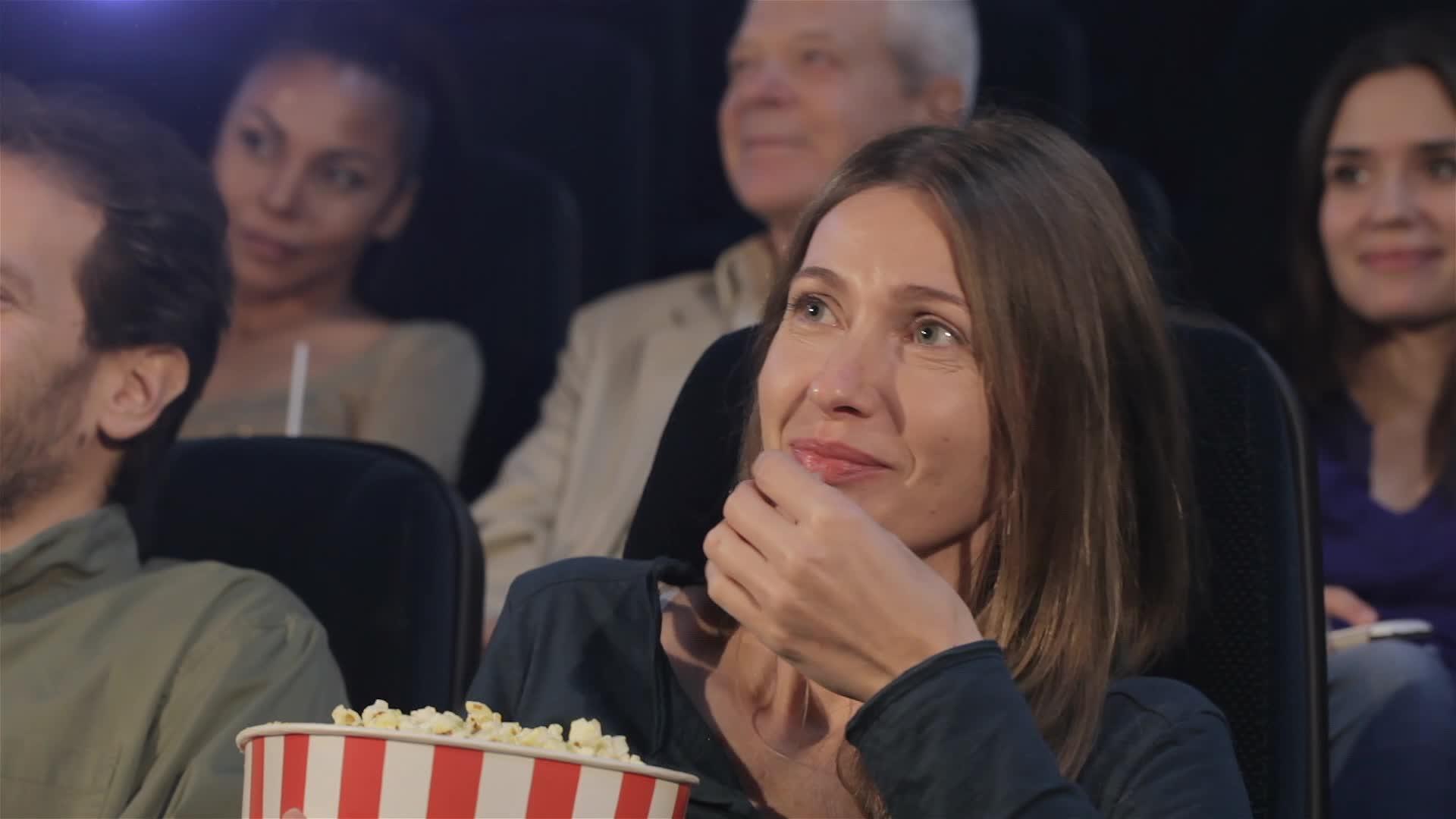 电影院里的女人把爆米花放进嘴里视频的预览图