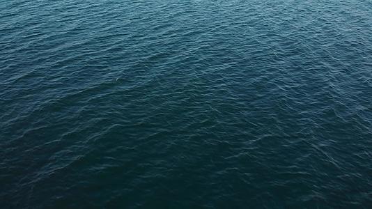 一艘白色游艇在蓝色无尽的海洋电影中倾斜和暴露视频的预览图