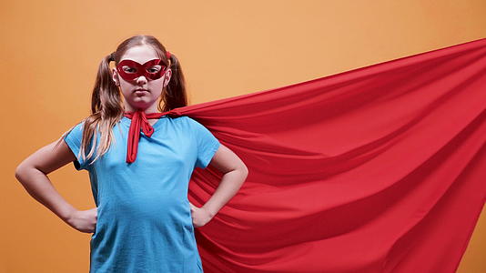 穿着超级超级英雄的小女孩的电影摄影斗篷被风吹走了视频的预览图