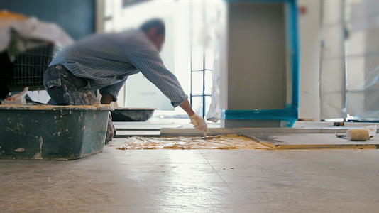 把阴铁瓷砖放在地板上的工人电影视频的预览图