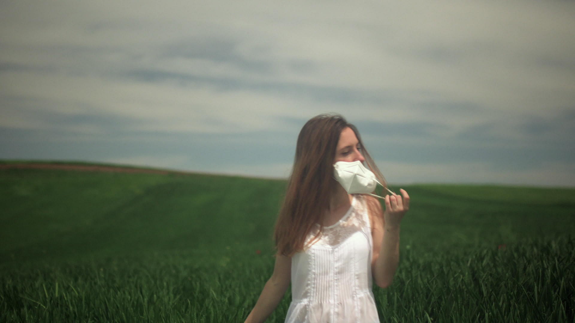 快乐的女孩摘下面具在田野里深呼吸视频的预览图