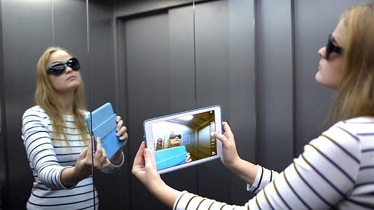 带着垫子的年轻女士在电梯上打扮拍照视频的预览图