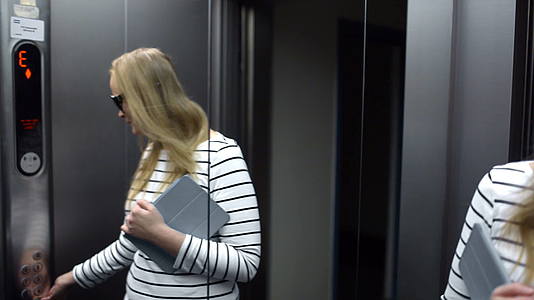 坐在电梯里的年轻女人在微笑视频的预览图