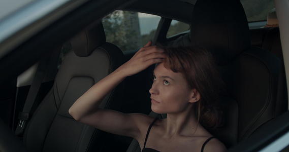 一个穿着电动汽车的可爱女孩看着她的头发和镜子里的化妆手视频的预览图