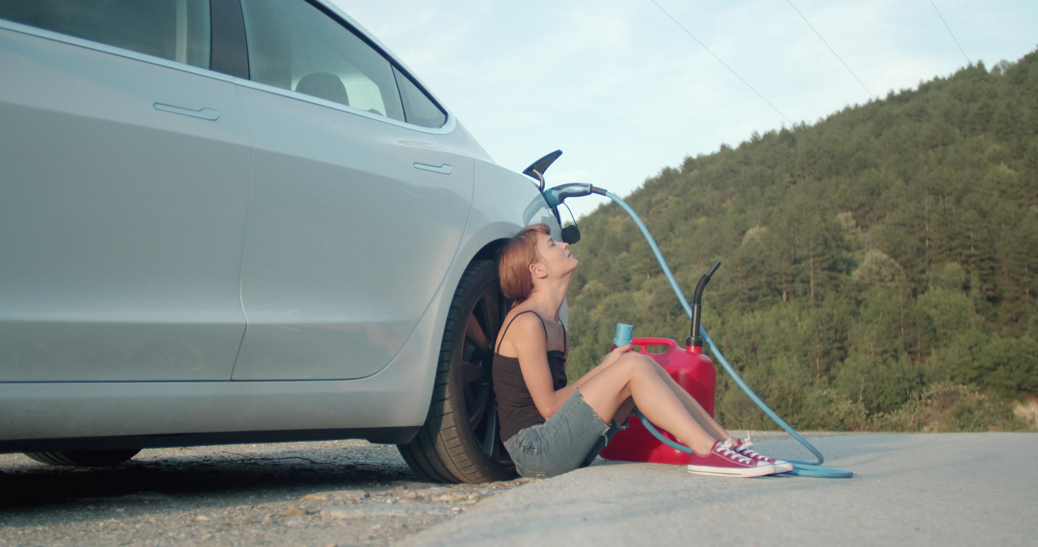 一个悲伤的女孩靠近一辆空电动汽车拿着充电电缆无处可塞没用视频的预览图
