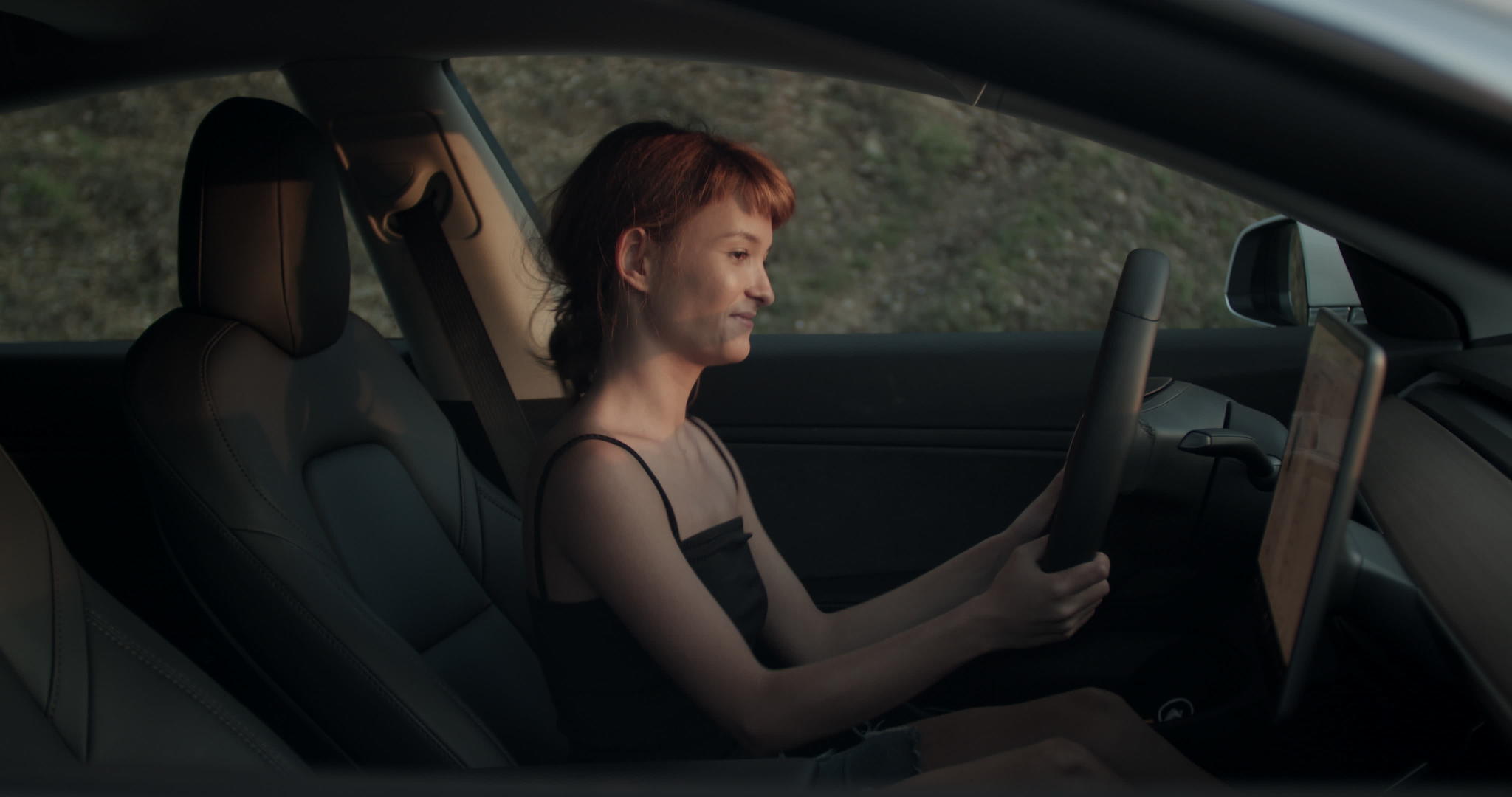 坐在司机的座位上听音乐和跳舞的手持视频在她的电动车里视频的预览图