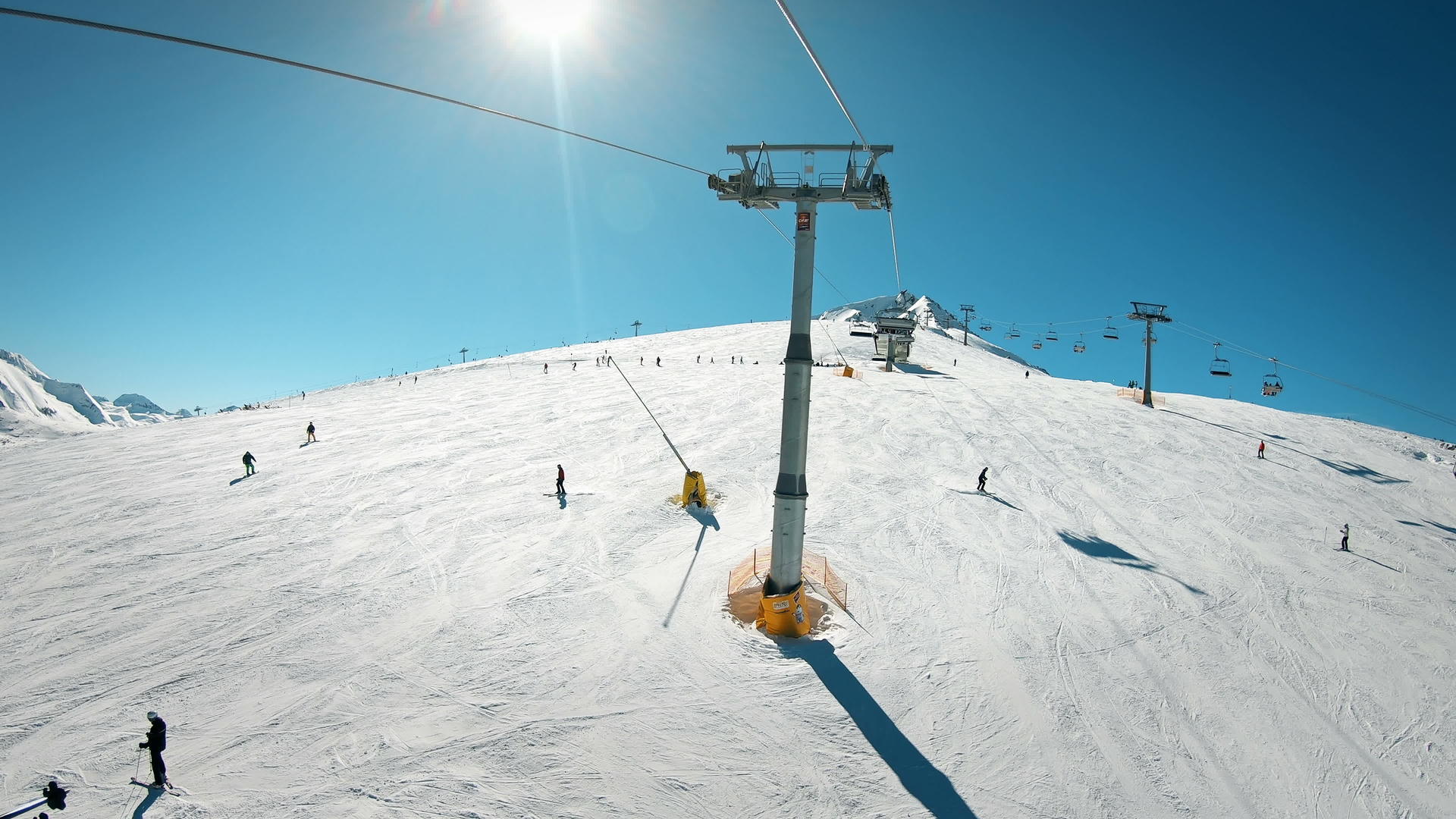 滑雪电梯在阳光明媚的日子到达山顶滑雪坡顶部视频的预览图