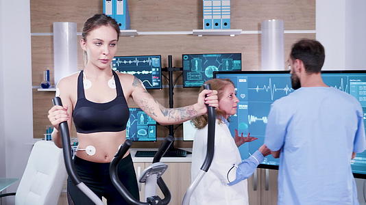 体育科学女医生在电视监视器上检查女运动员的能量视频的预览图