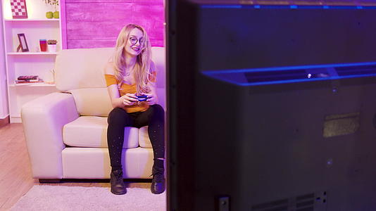 在网上玩电子游戏的金发女郎展现了欢快的视频剪辑视频的预览图