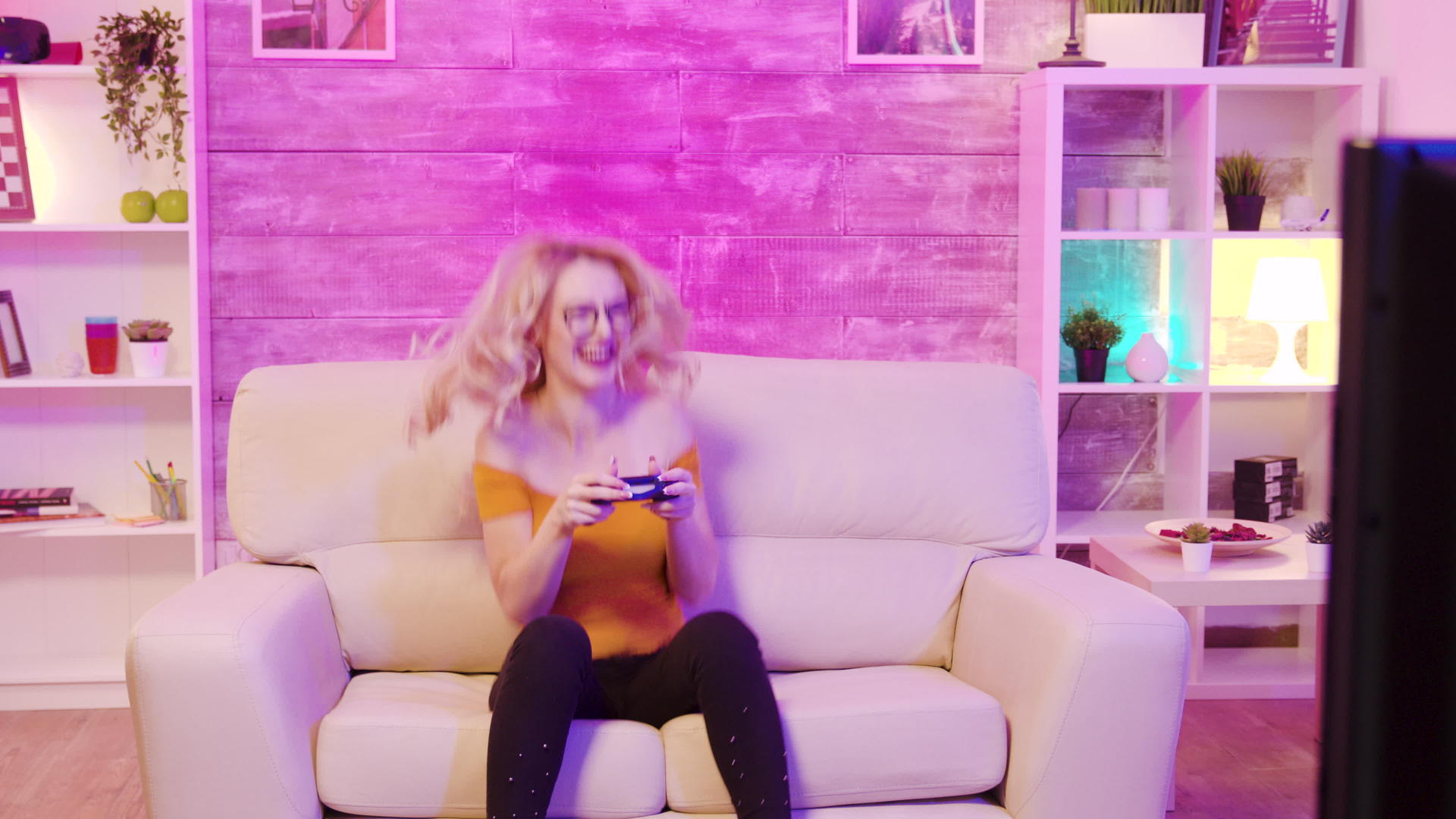 美丽的金发女孩在玩电子游戏时非常兴奋视频的预览图