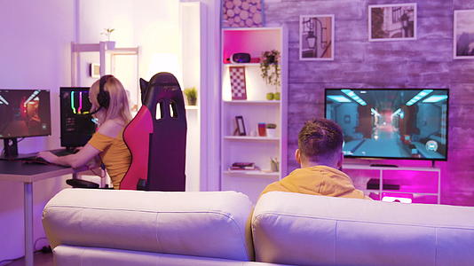 一对夫妇在五颜六色的房间里玩网络电子游戏视频的预览图
