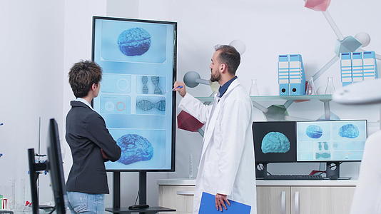 在医学研究设施中穿着白色长袍的医生给了病人3个D脑模拟视频的预览图