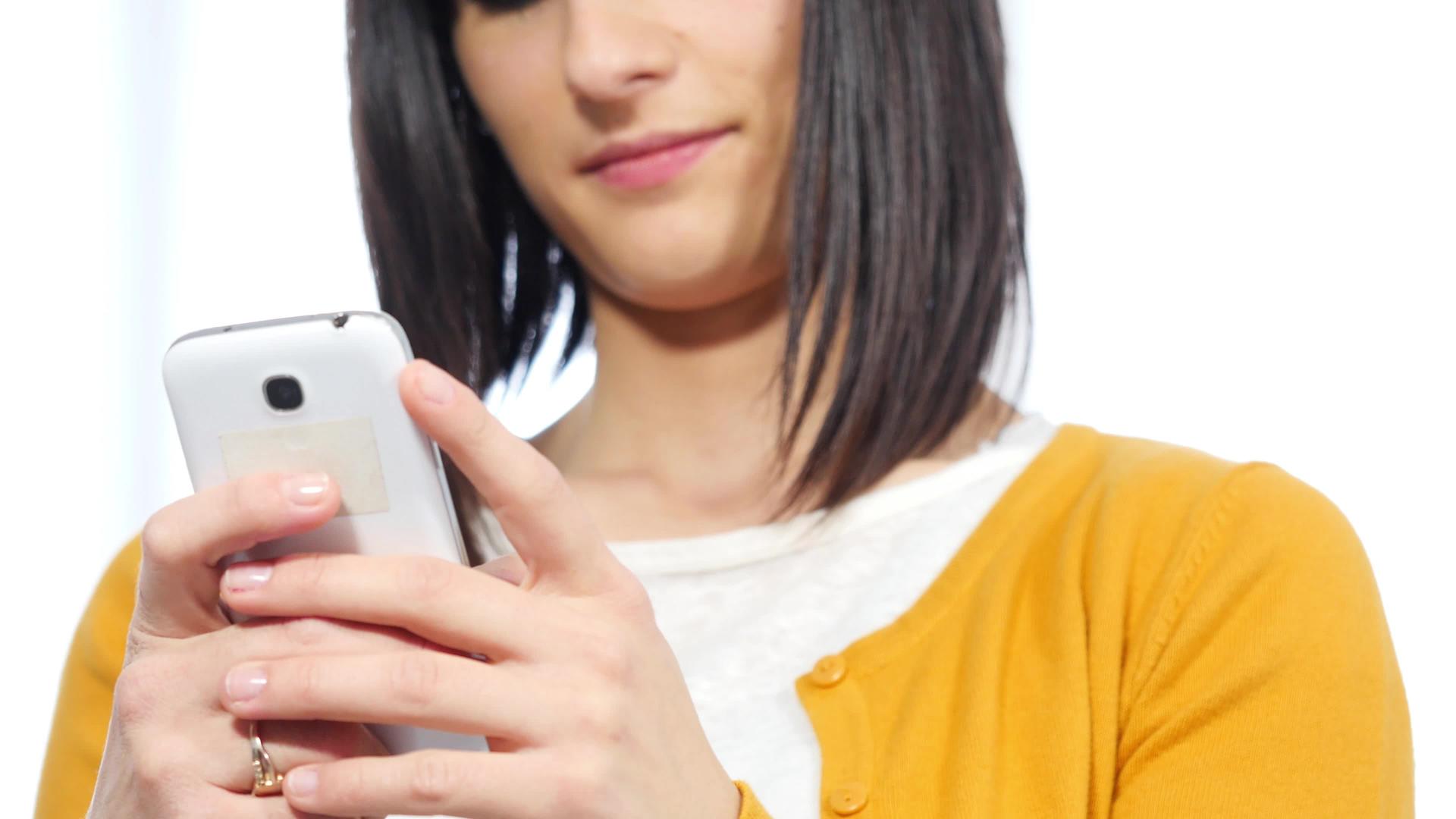 年轻的黑发女人用电话发短信视频的预览图