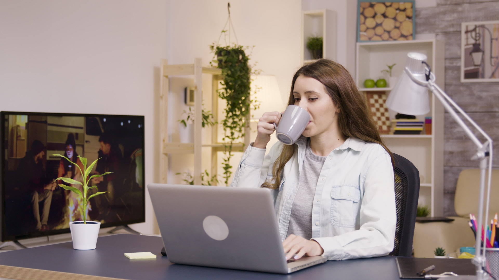 在家做笔记本工作时喝咖啡的女孩视频的预览图