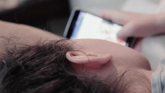 女性和女性在社交网络上对躺在床上的智能手机电影Dof视频的预览图