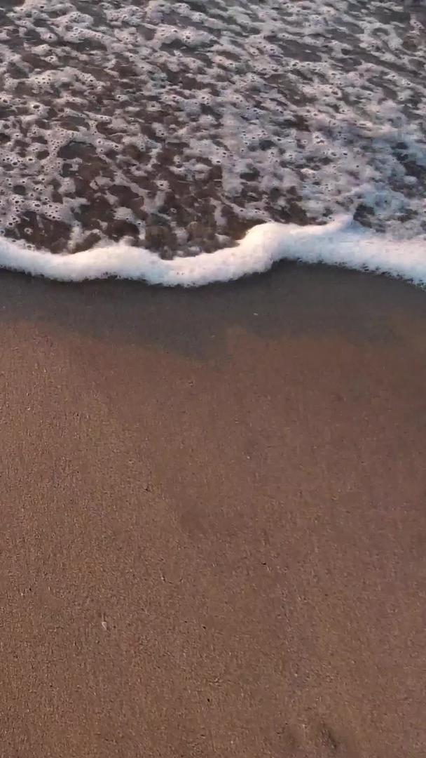 在海边沙滩上拍摄海浪起落的视频视频的预览图