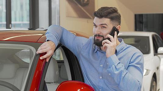 胡子人在汽车经销店打电话视频的预览图