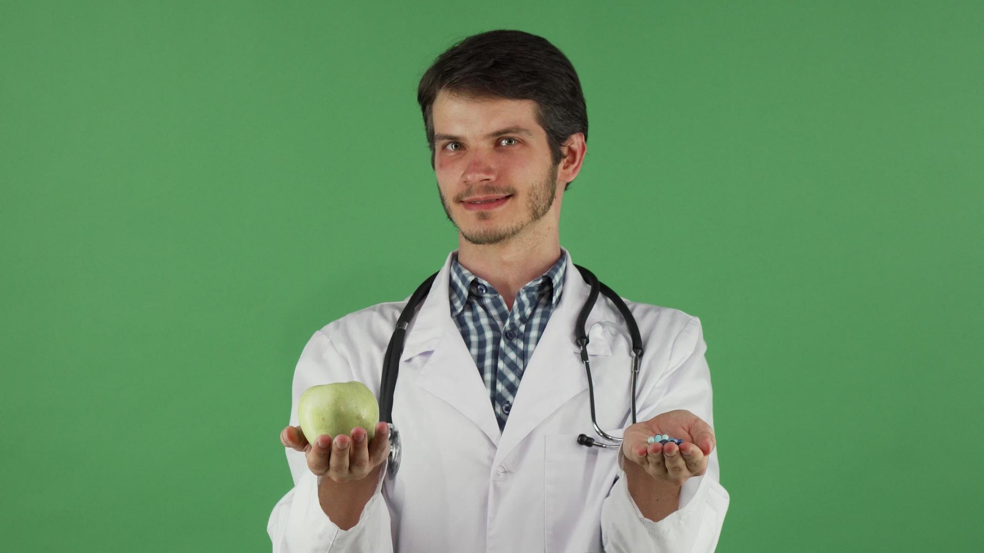 年轻医生拿着绿苹果和药丸视频的预览图
