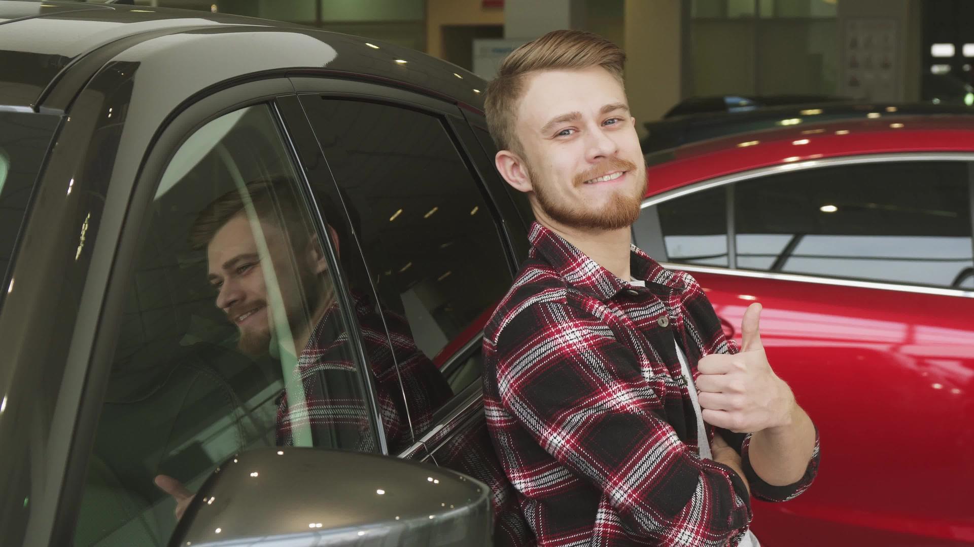 帅哥靠在经销商的新车上竖起大拇指视频的预览图