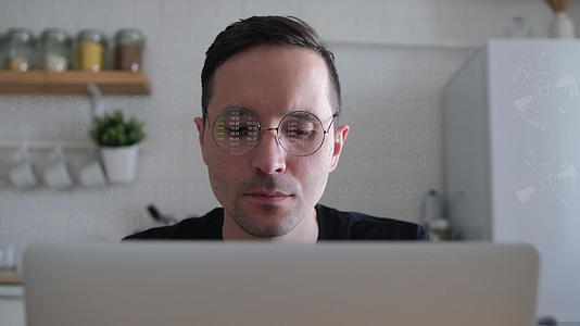 一位年轻的高加索商人在电脑显示器前工作在家里的厨房工作视频的预览图