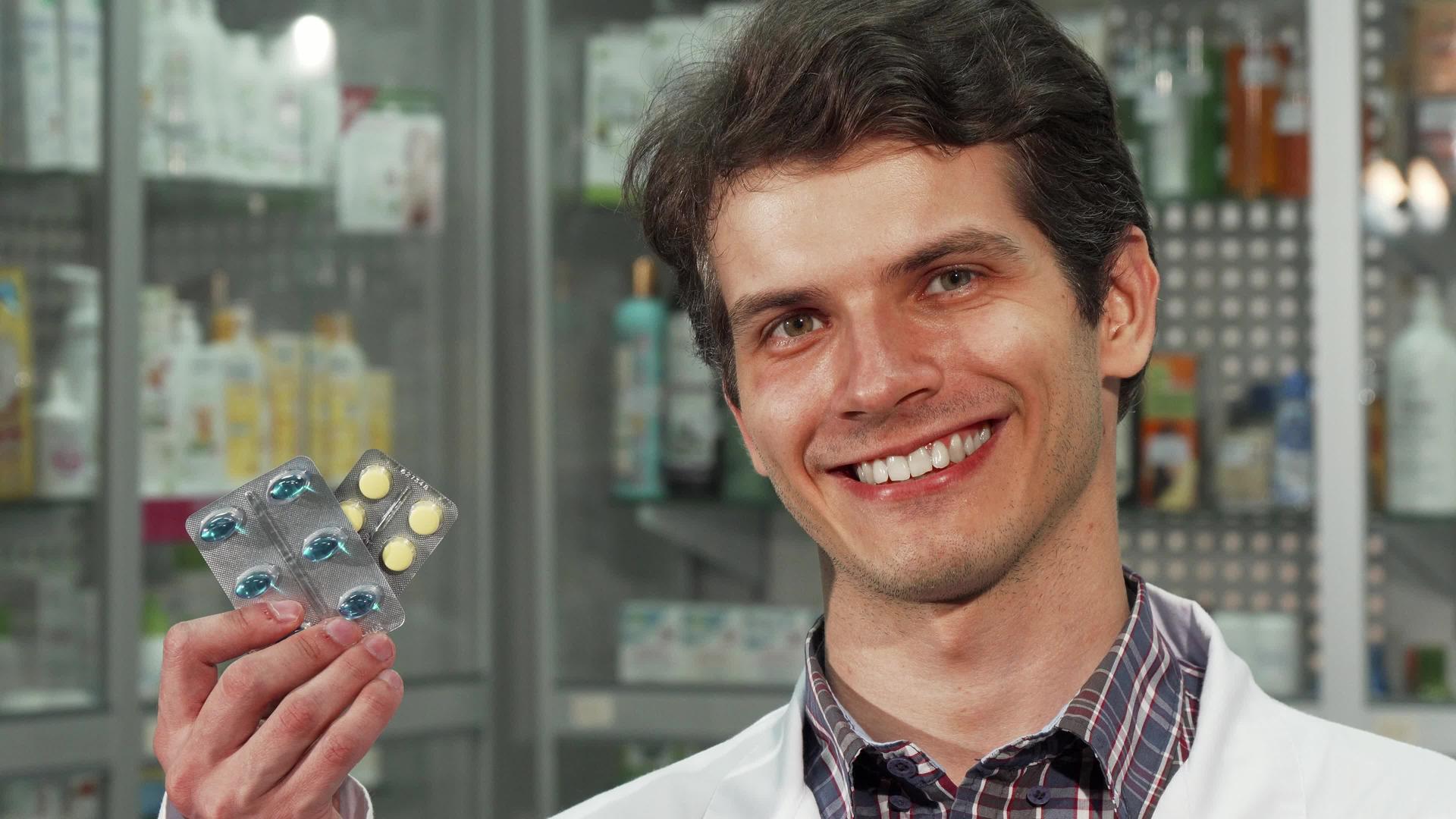 快乐的男性化学家微笑着拿着两片药片视频的预览图
