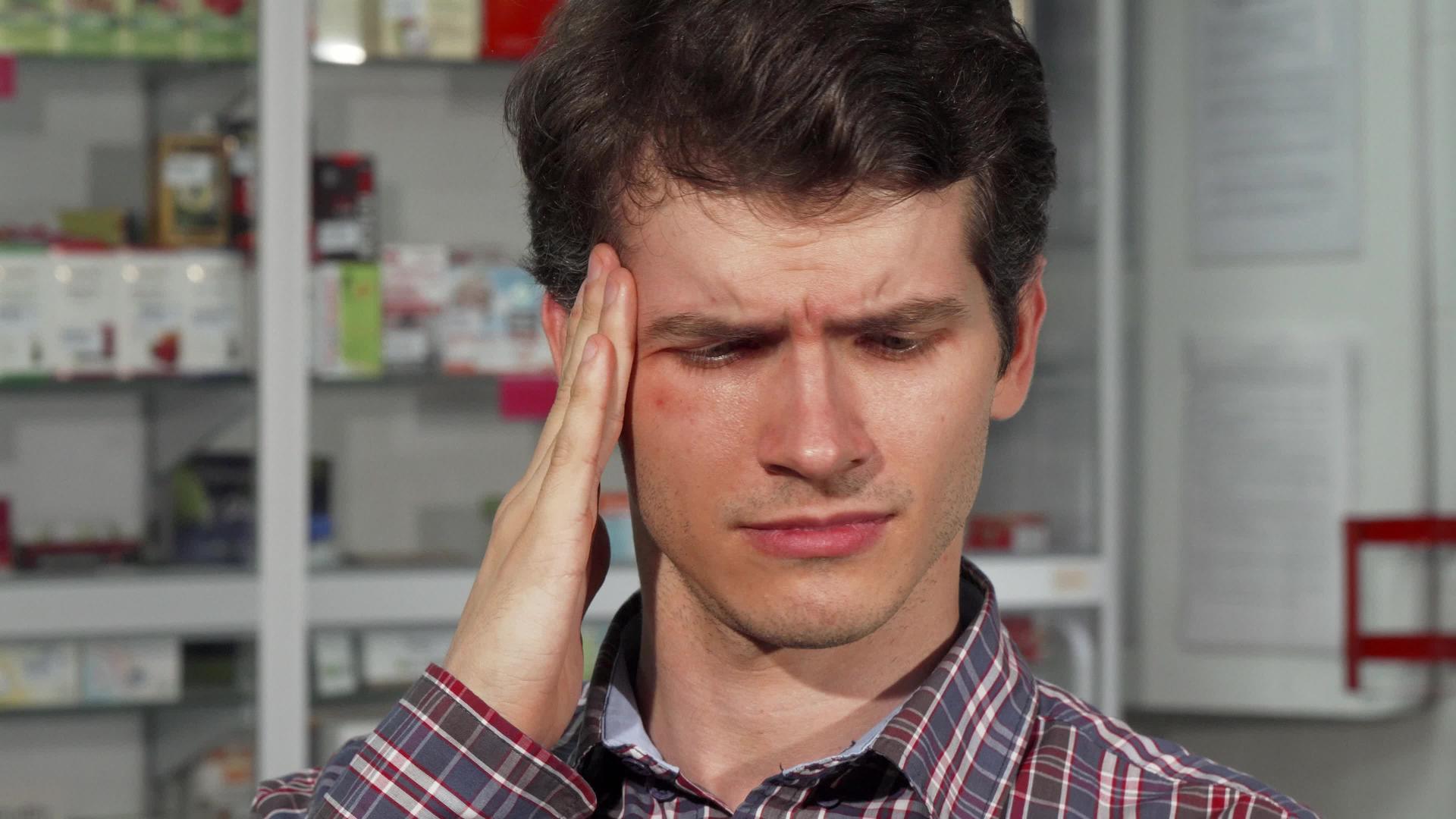 头痛的年轻男子持有药丸视频的预览图
