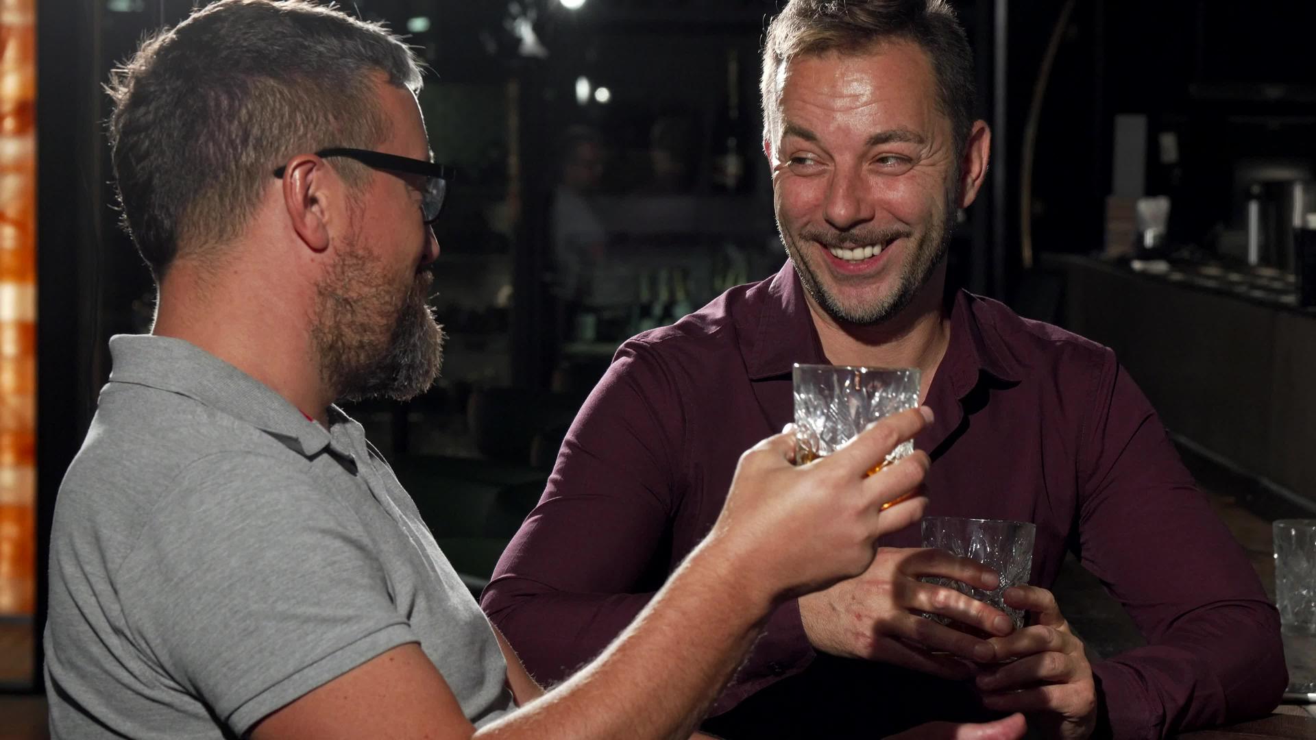 两个朋友一起喝酒一边笑着看着镜头一边喝酒视频的预览图