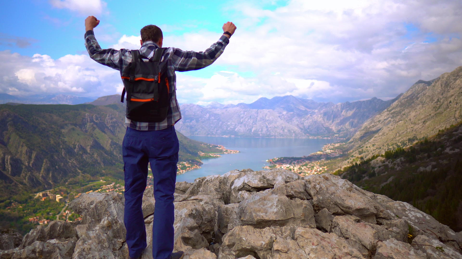 男性旅行者站在山顶双手举起双手视频的预览图
