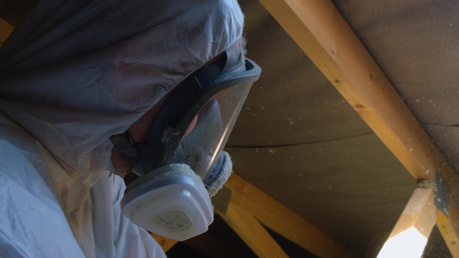男人在呼吸器面具中制造热屋顶绝缘材料视频的预览图
