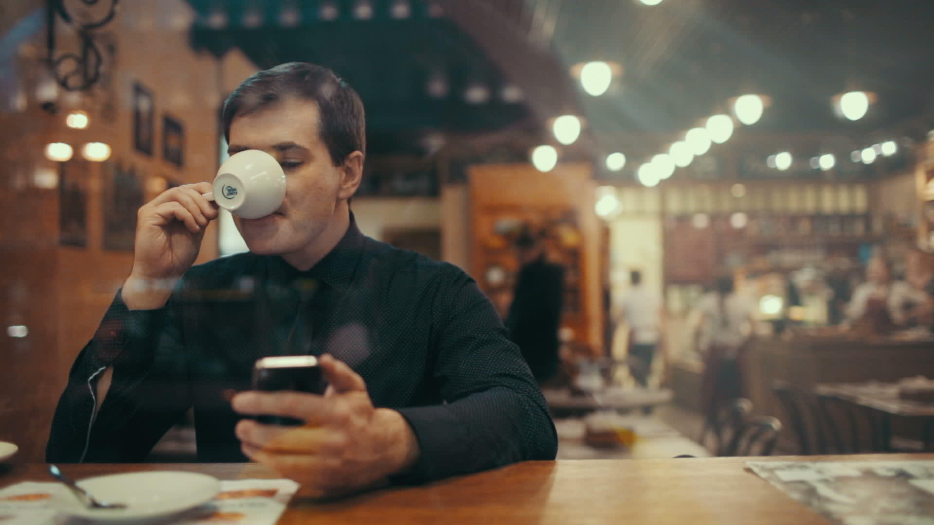 咖啡馆里的年轻人用电话喝咖啡视频的预览图