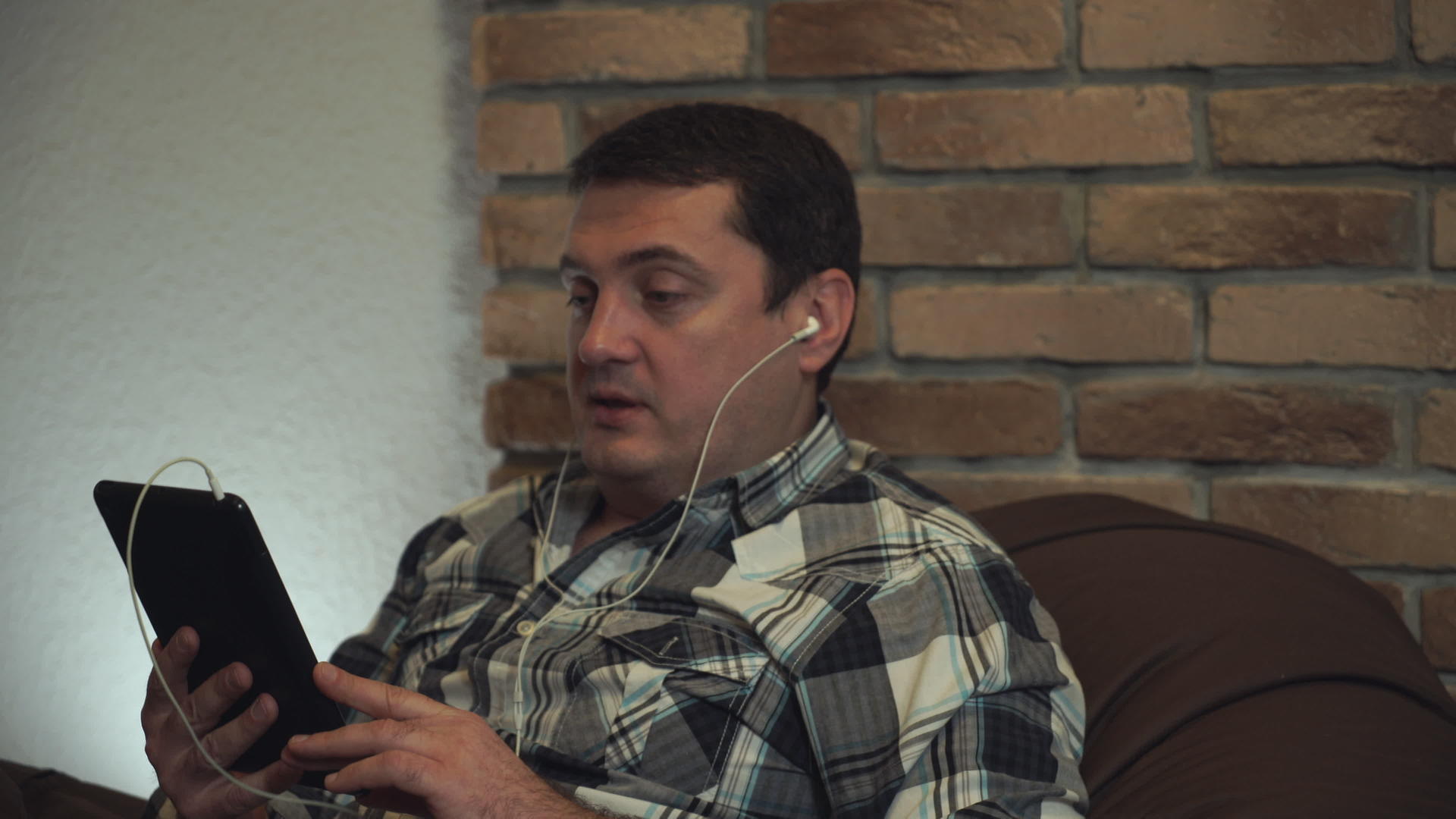 男人通过平板电脑用耳机说话视频的预览图