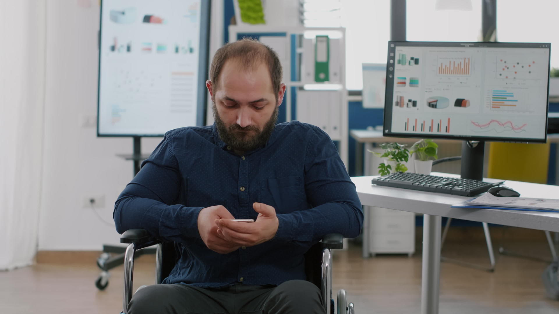 残疾企业家在工作期间持有智能手机短信视频的预览图