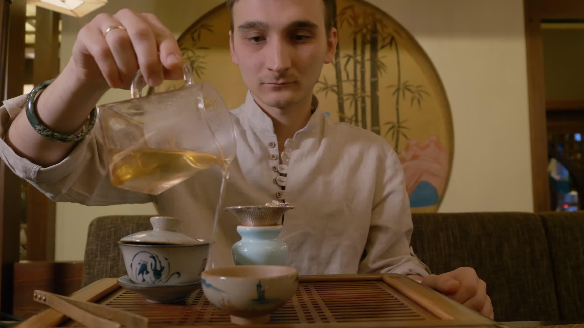 男人倒热绿茶从公平的投球到碗和饮料的杯子和饮料视频的预览图