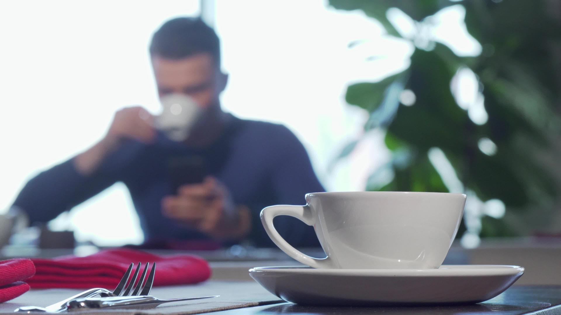 喝咖啡或茶吃早餐的男人在背景中享受早餐视频的预览图