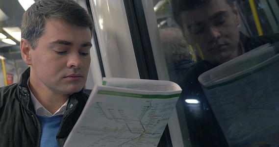 男子有报纸在地铁列车上旅行视频的预览图