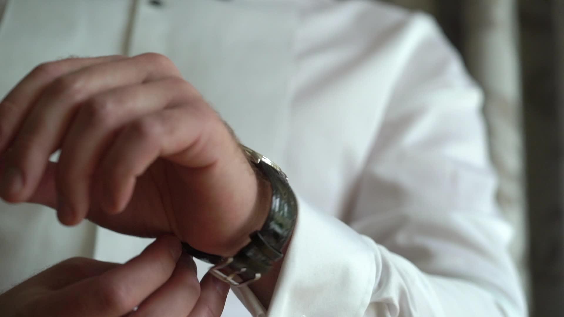 商人在手表上检查时间男人把手表放在新郎手里视频的预览图