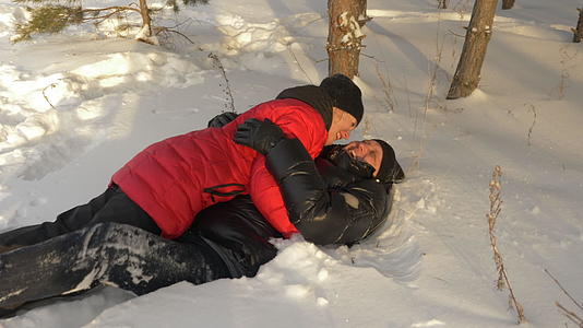 男人和女人在冬天的森林里玩得很开心视频的预览图