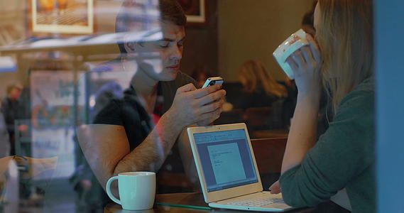 拥有智能手机和咖啡馆膝盖电脑的年轻人视频的预览图