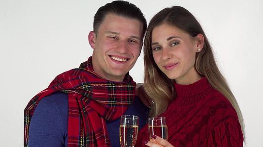 年轻情侣微笑用香槟杯向相机敬酒视频的预览图