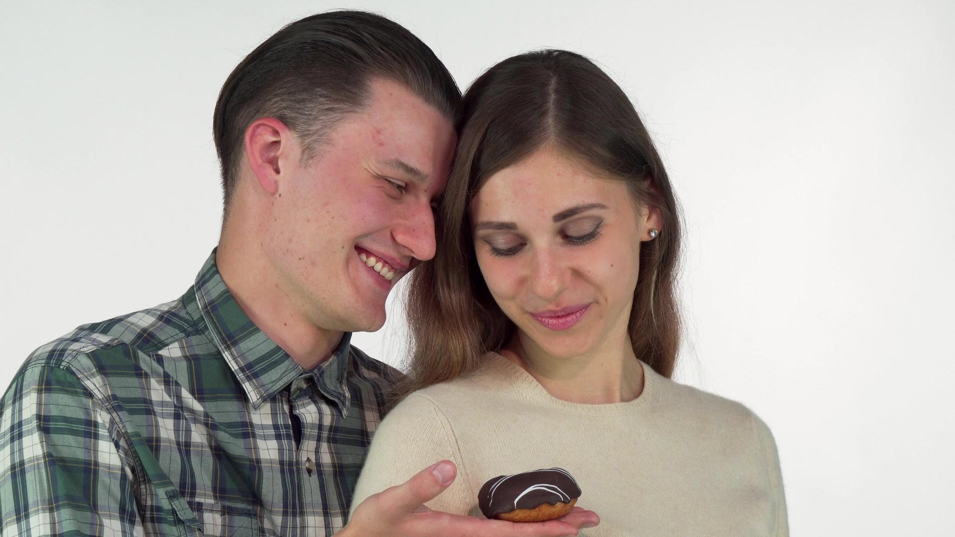 年轻男子微笑为漂亮的女朋友提供巧克力甜甜甜甜甜甜甜的圈视频的预览图