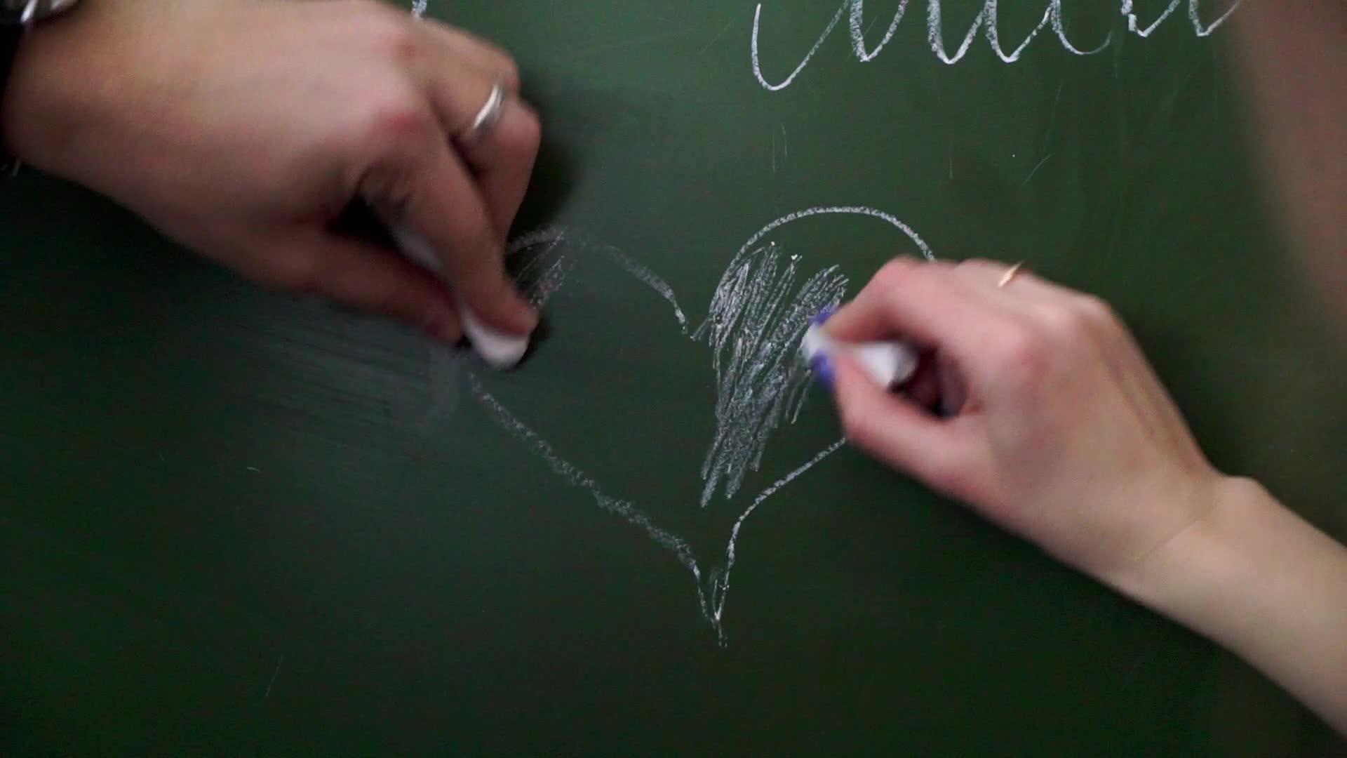 在校学生在粉笔板上吸引人心视频的预览图