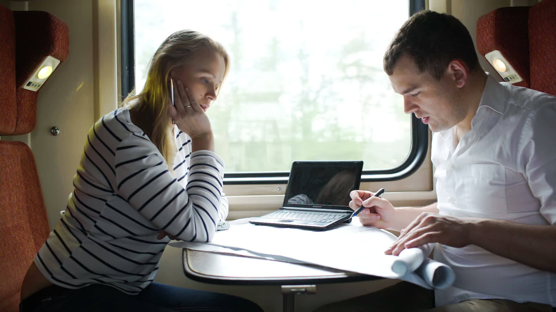 男人和女人在火车上出差时讨论绘画问题视频的预览图