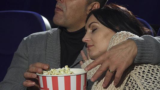 成年妇女睡在丈夫的肩膀上睡在电影院里视频的预览图