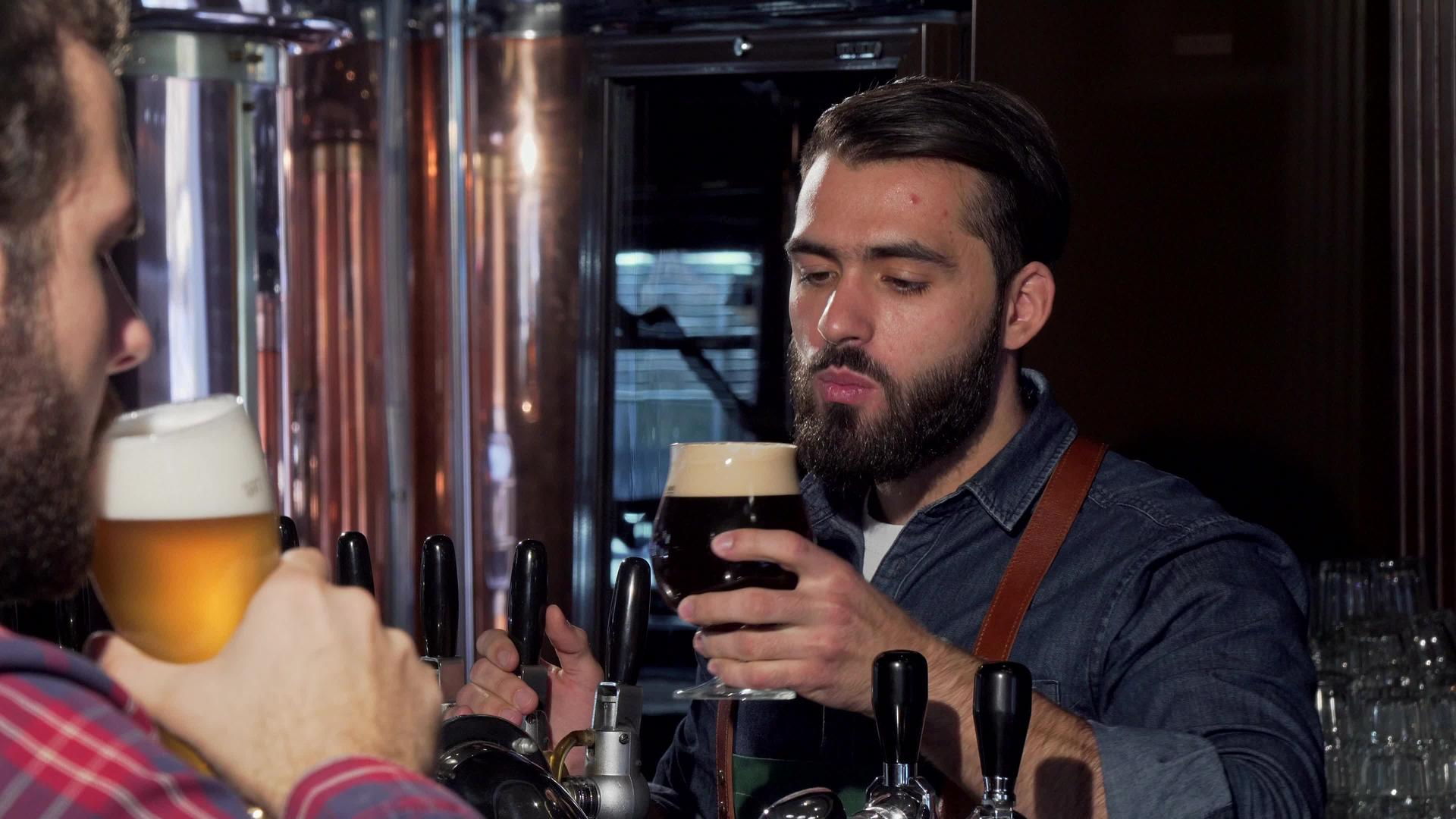 长胡子的酒保和顾客喝啤酒视频的预览图