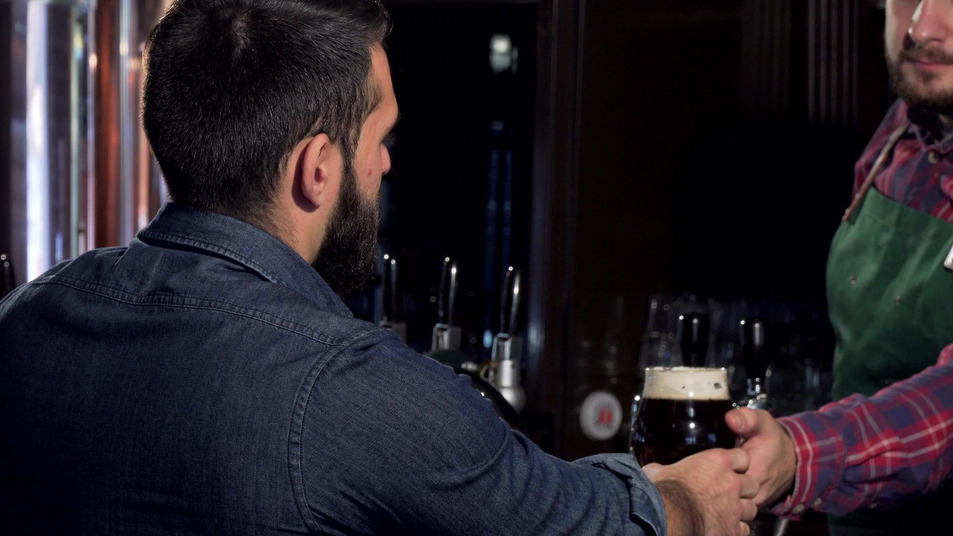 在酒吧里喝美味工艺啤酒的男人无法辨认视频的预览图
