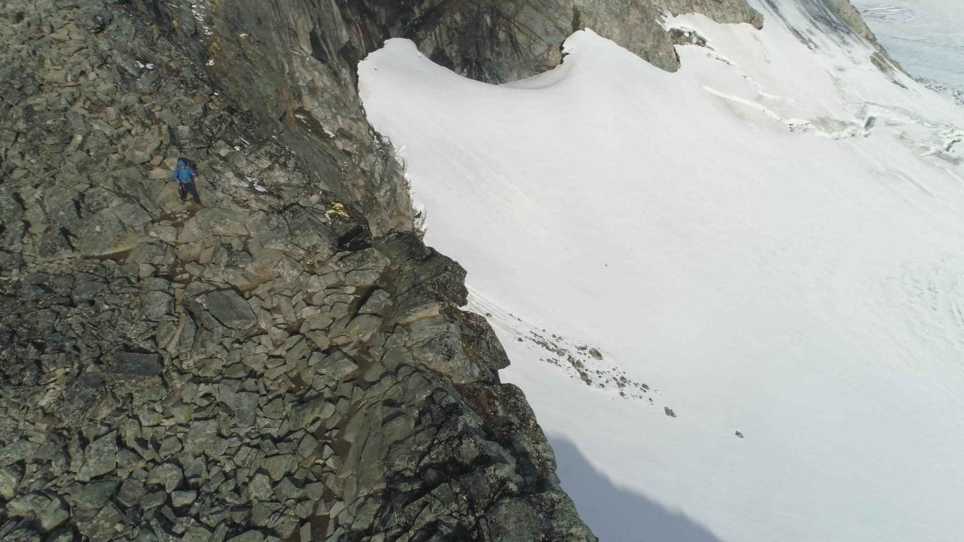 登山者在悬崖附近的雪山上徒步无人驾驶飞机视频的预览图