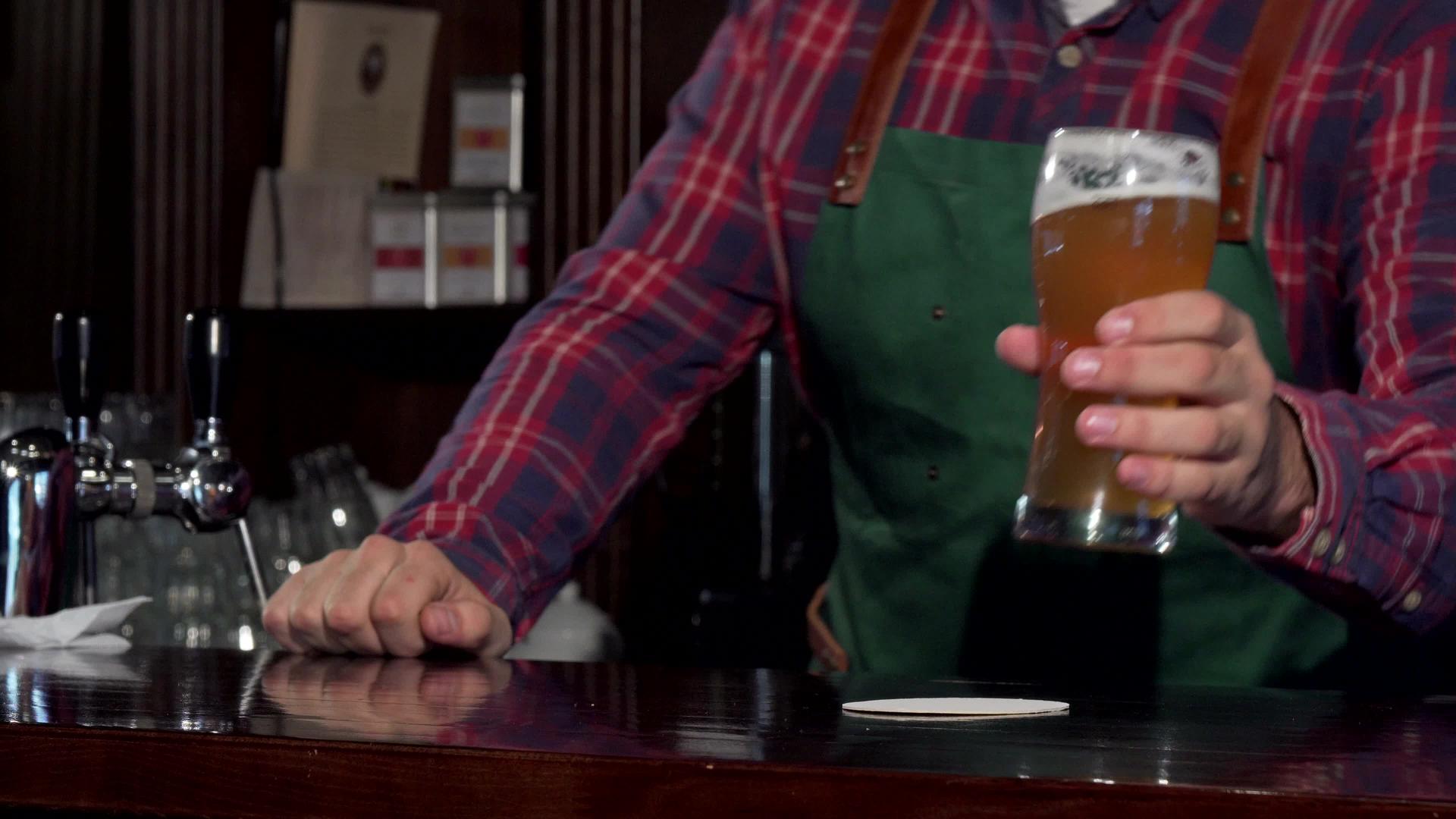 酒保笑着把啤酒杯放在柜台的柜台上视频的预览图