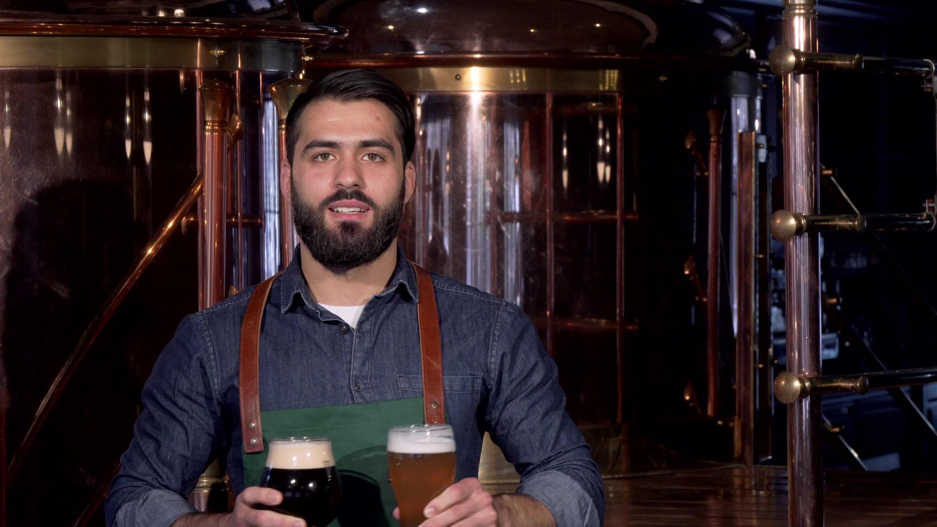 专业酿酒师在他的酿酒厂举着两杯啤酒杯高兴地笑了视频的预览图